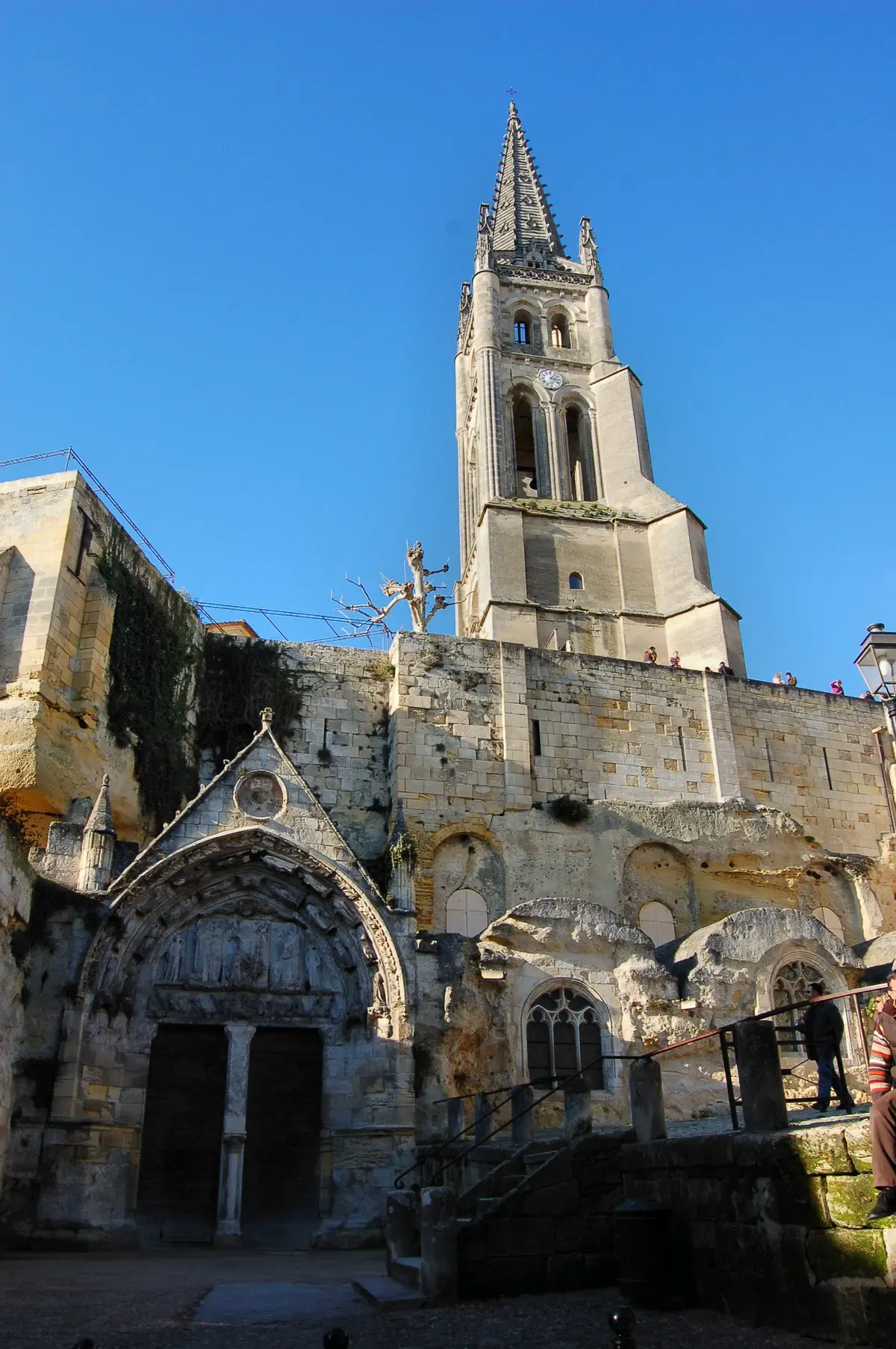 The bell tower and carved portal of the monolithic church in Saint-Émilion, seen on a Bordeaux wine day tour